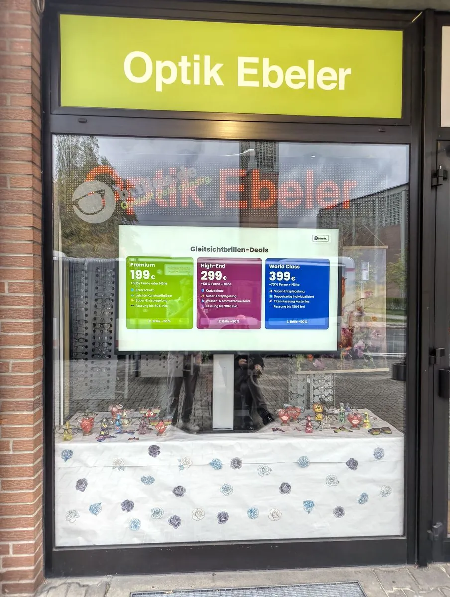 Hochformat-Display mit Brillen-Angeboten im Schaufenster von Optik Ebeler