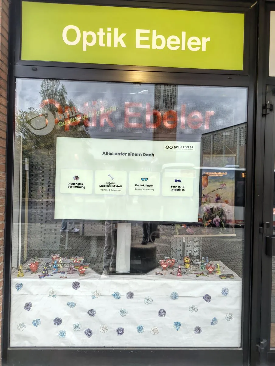 Hochformat-Display mit Services und Öffnungszeiten von Optik Ebeler